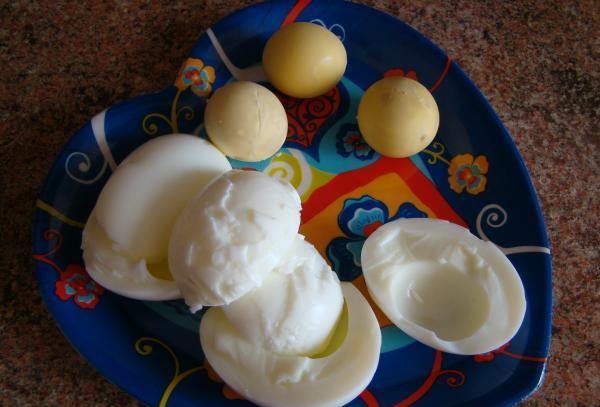 Разделённые на белки и желтки варёные яйца на тарелке в форме сердца