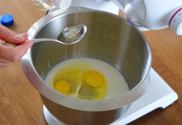 Сметана и сырые яйца в металлической чаше миксера