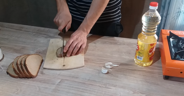 Мужчина режет хлеб соломкой