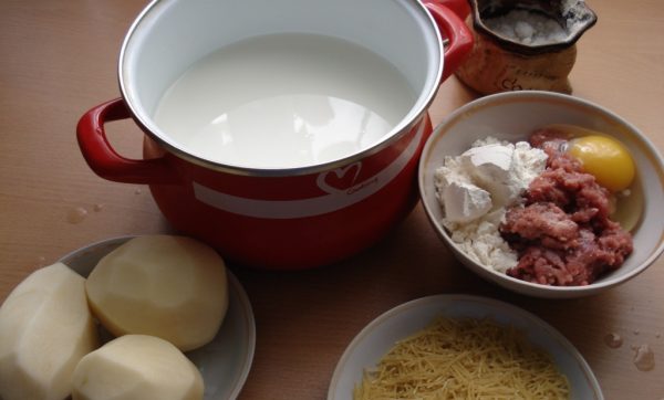 Продукты для приготовления молочного супа с вермишелью и фрикадельками на столе