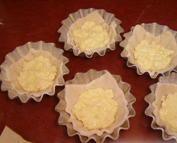 Металлические порционные формы для кексов с кусочками сырого теста и творожной массой